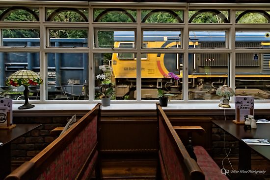 Bar room with tables and train passing window.