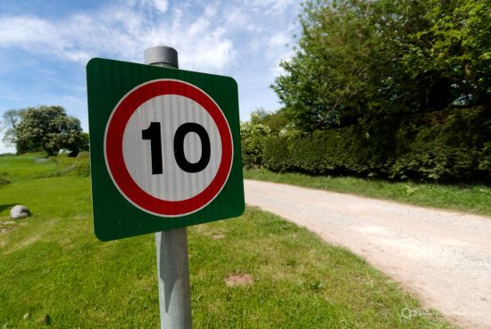 A sign showing a 10MPH speed limit in a rural setting