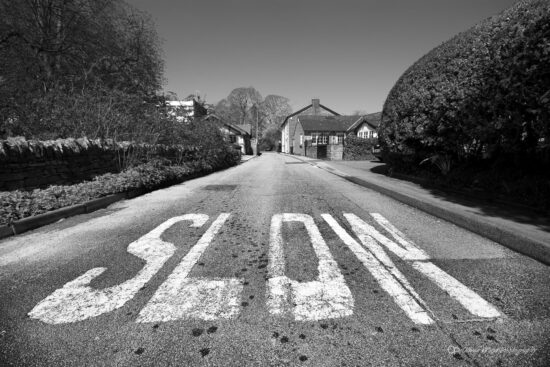 Black and white image of slow speed advisory on road